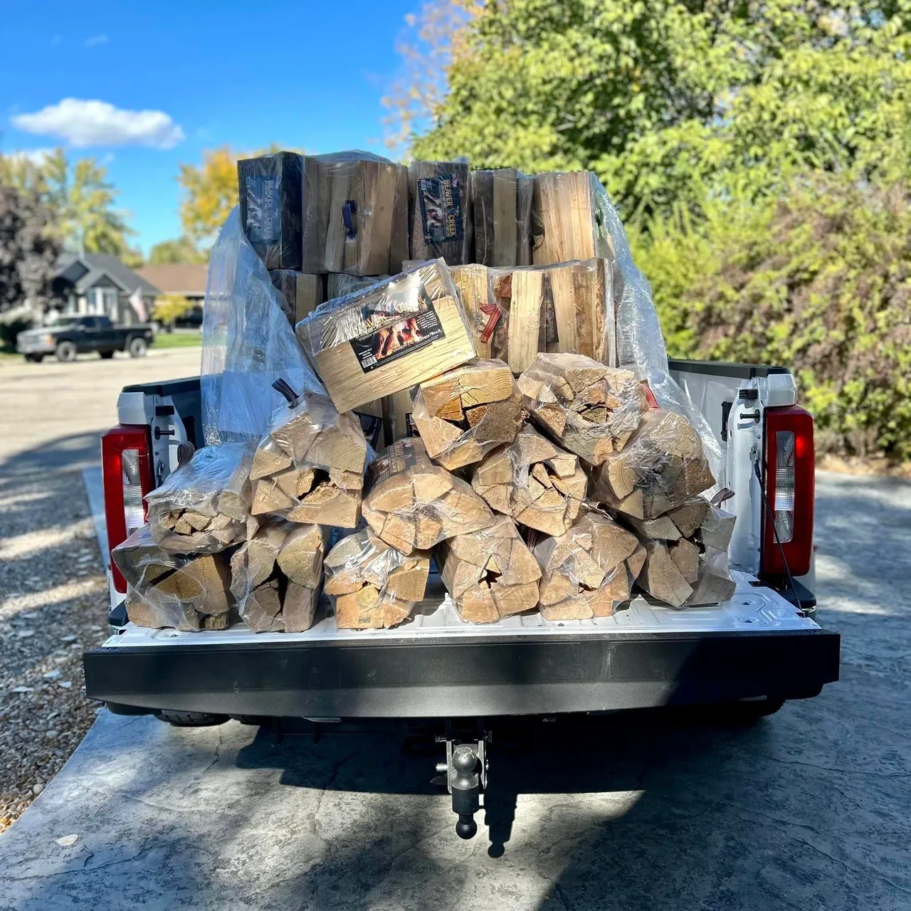 A truck with firewood in the back of it.