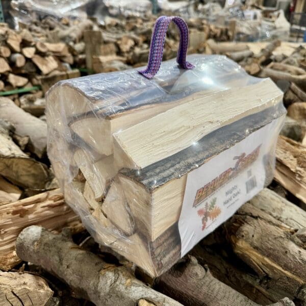 A bag of firewood with a purple handle.