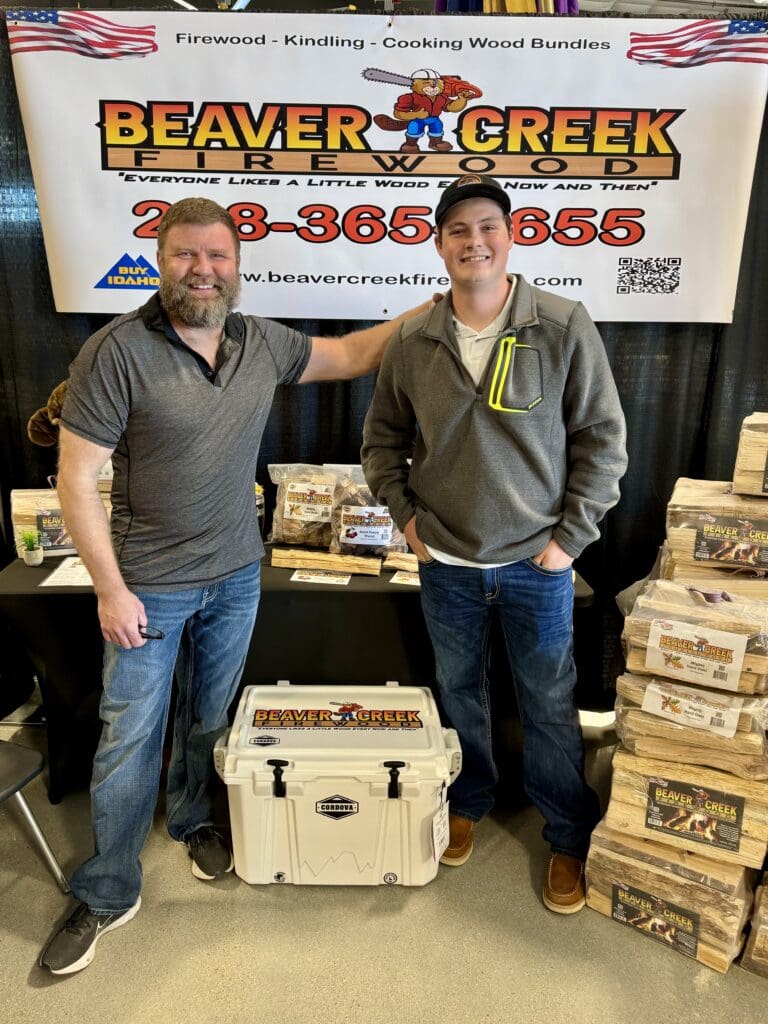 Two men standing with Beaver Creek firewood.